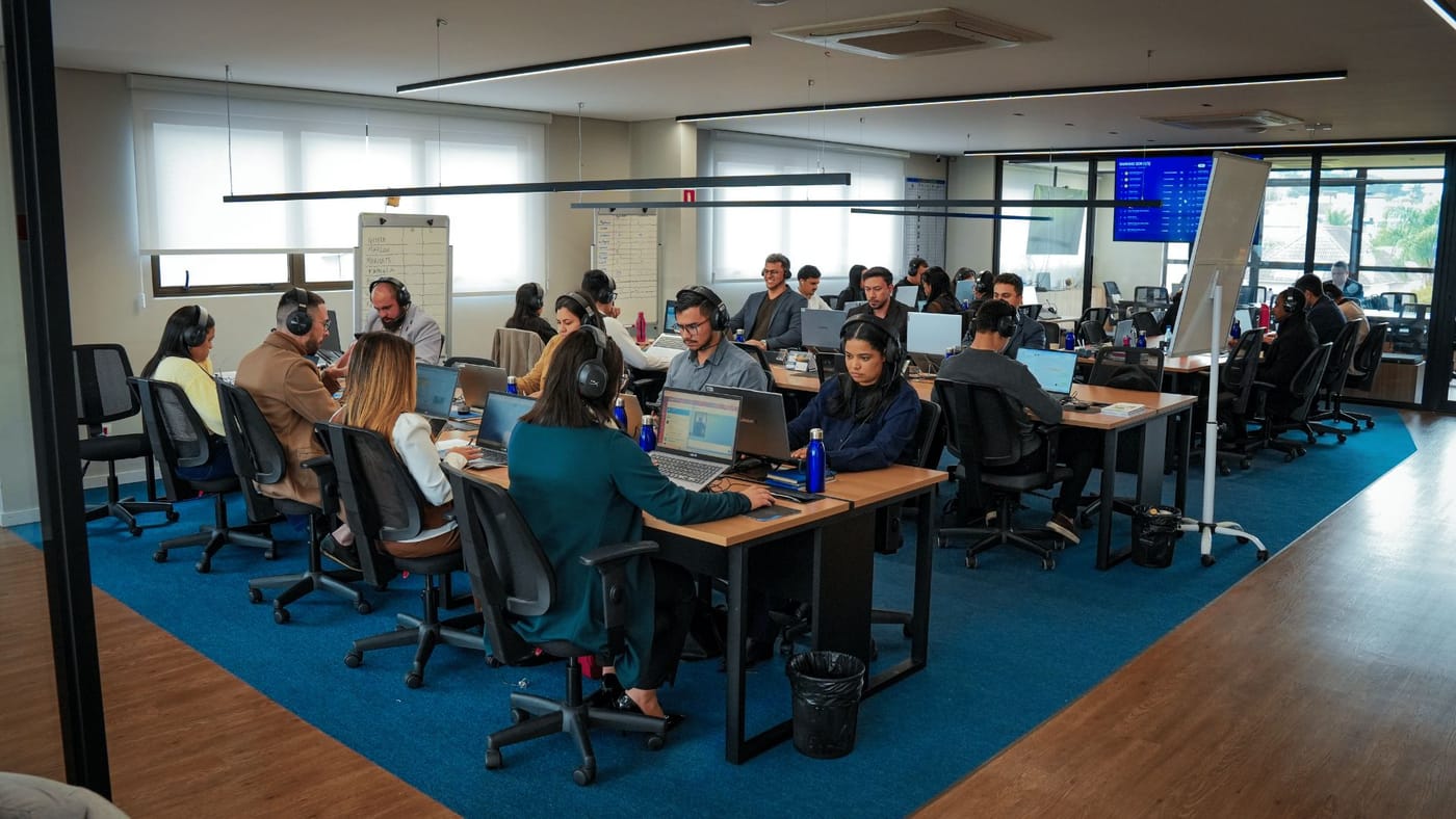 Vista ampla do salão de operações, com a equipe em atendimento