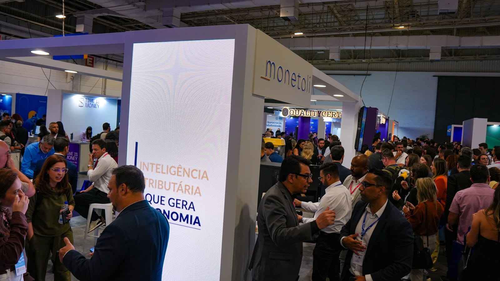 Painel do estande com a mensagem “Inteligência tributária que gera economia”